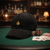 Casquette poker « Pique Doré » posée sur une table de poker avec jetons et cartes