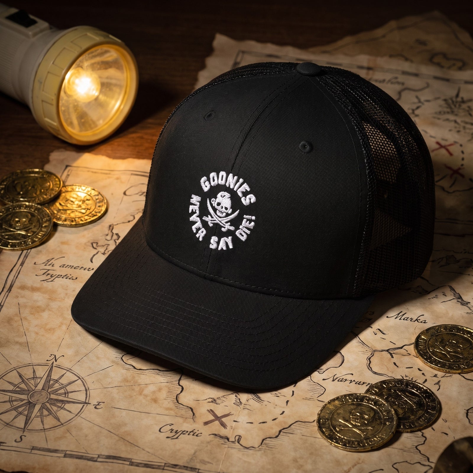 Casquette Goonies Never Say Die posée sur une carte au trésor, ambiance années 80