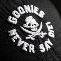 Macro de la broderie blanche Never Say Die sur la casquette Goonies noire
