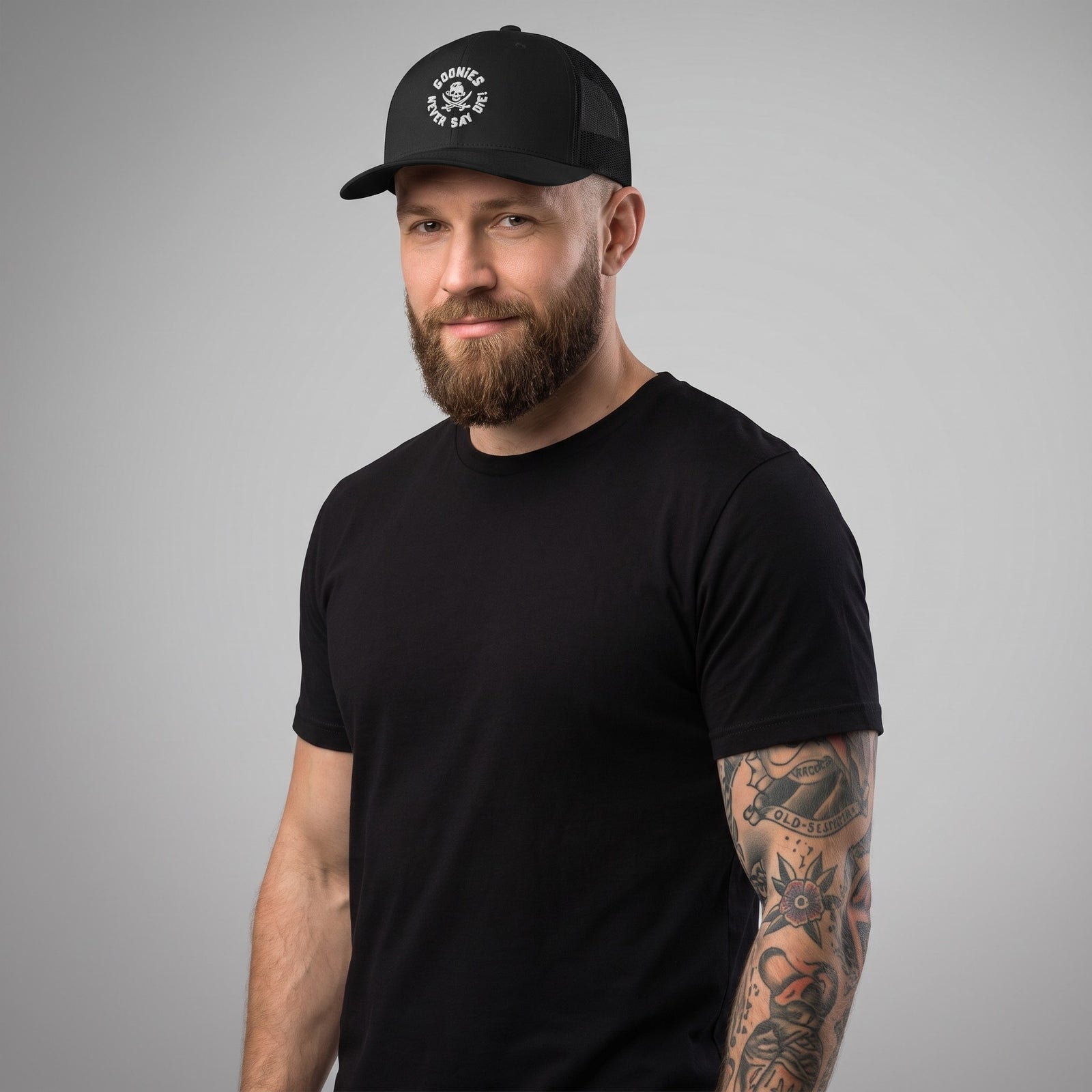 Homme portant la casquette trucker originale Goonies Never Say Die noire, photo studio