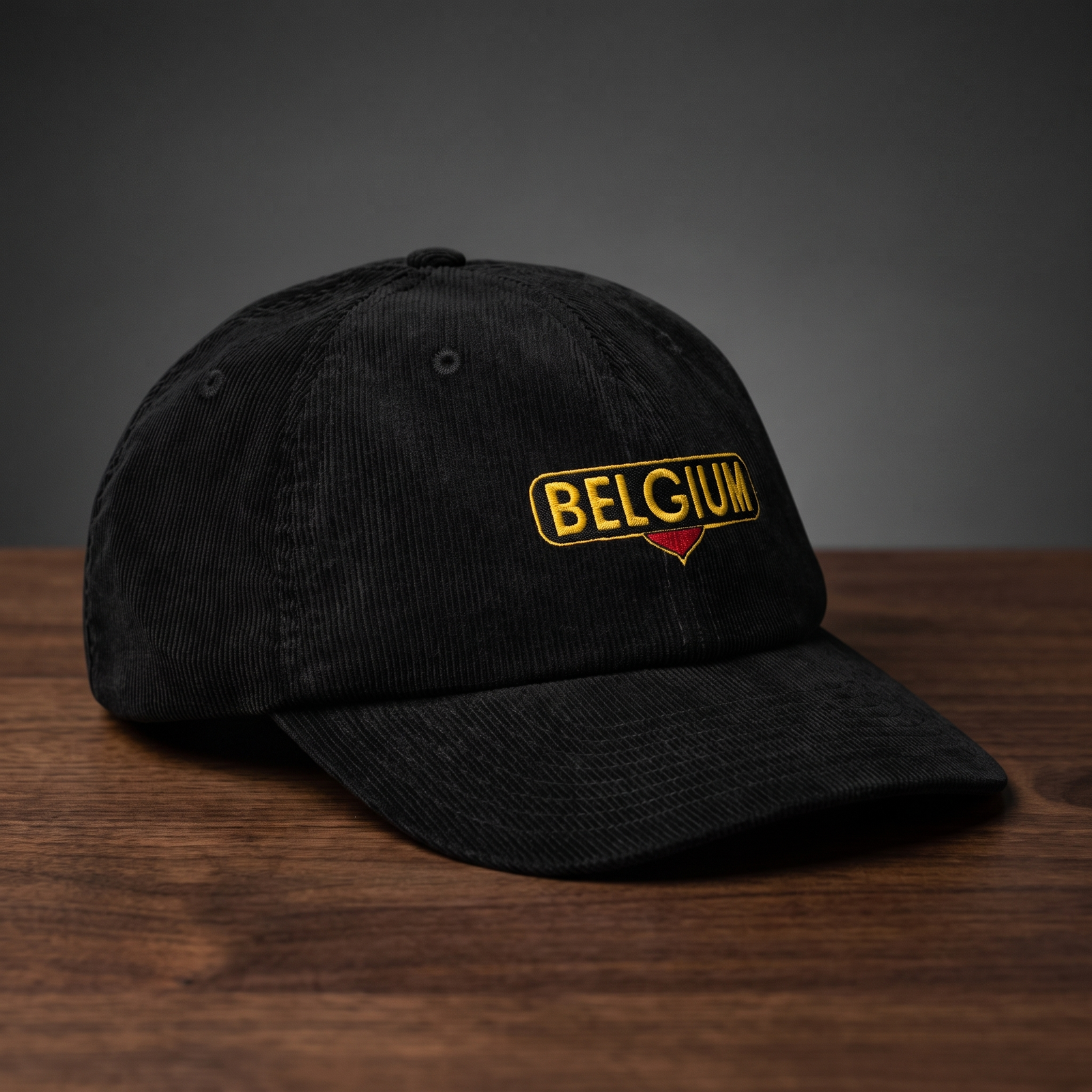 Casquette belge en velours côtelé noire Belgium - vue de profil trois-quarts sur fond bois et charbon