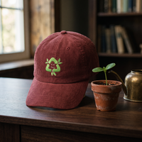 Casquette en velours côtelé bordeaux CHT'M Boutique avec broderie écologie recyclage - mise en scène pot de fleur terre cuite bois noyer foncé