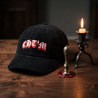 Casquette dad cap en velours côtelé noir CHT'M Gothique Rouge posée sur bois avec cachet de cire et chandelier