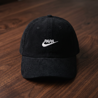 Casquette en velours côtelé noir brodée PAPA avec logo swoosh style Nike blanc, vue produit angle léger, CHT'M Boutique