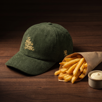 Casquette en velours côtelé olive brodée Le pays de la frite, CHT'M Boutique, mise en scène avec frites belges et mayonnaise sur bois de noyer foncé