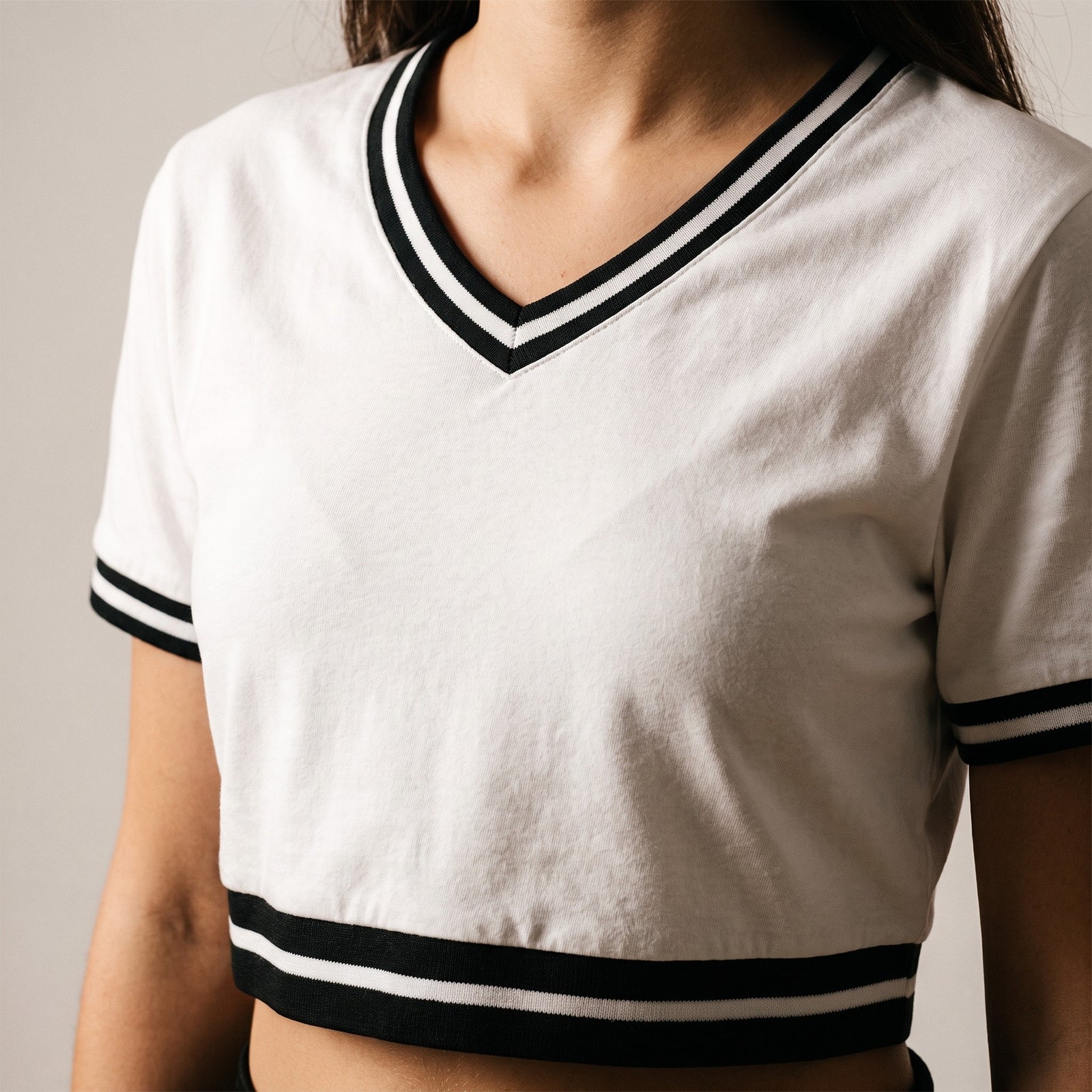 Gros plan du crop top col v original femme blanc : coupe, col et texture du tissu