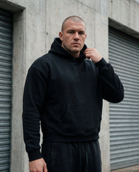 Hoodie boxy bord brut noir CHT'M porté en ville — streetwear belge unisexe