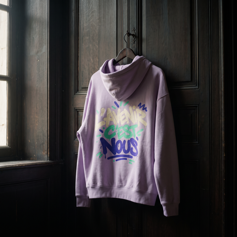 hoodie boxy Gen Z « L'avenir c'est nous » lilas suspendu sur un cintre en bois – sweat Gen Z original CHT'M