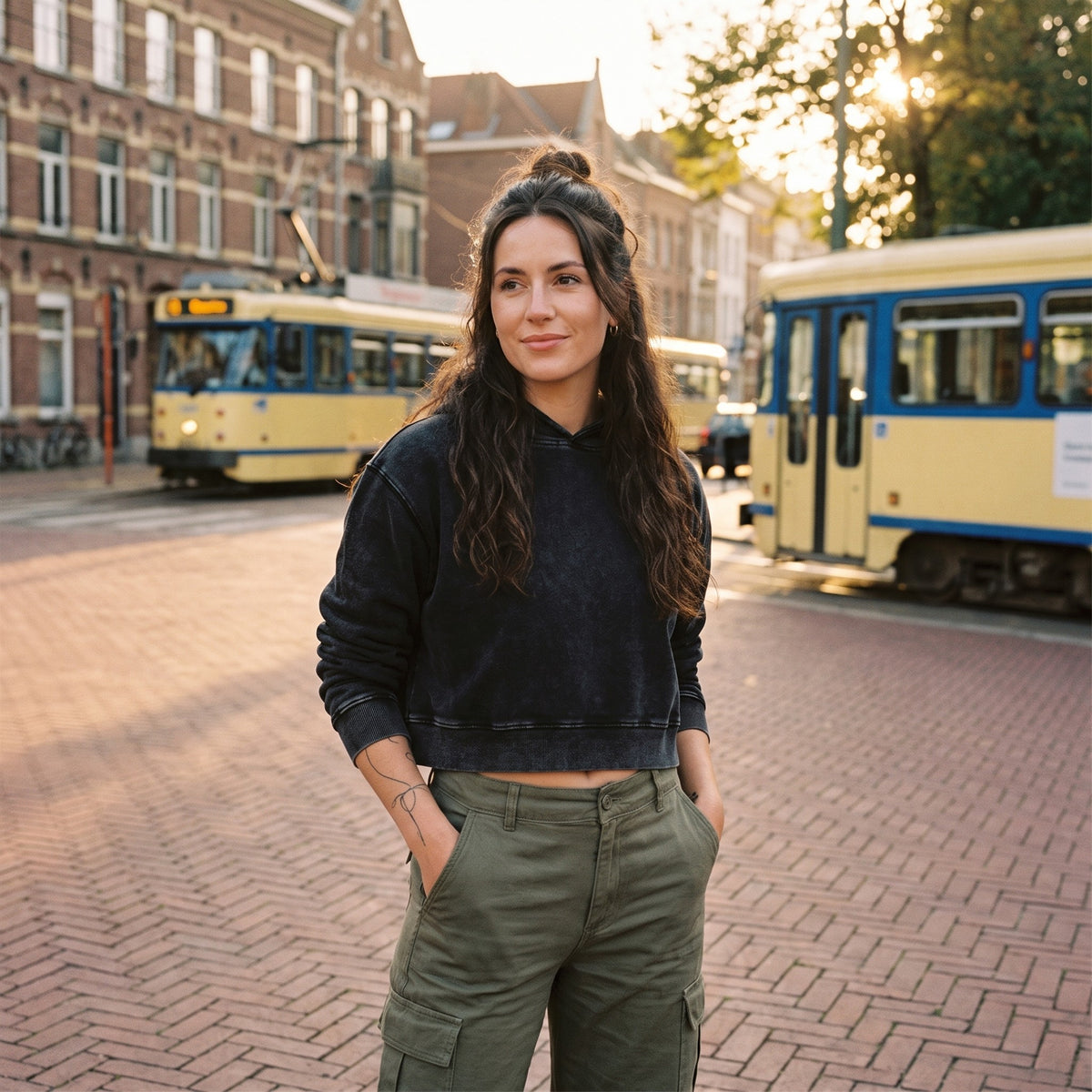 Hoodie crop top femme délavé noir porté dans une rue belge avec tram