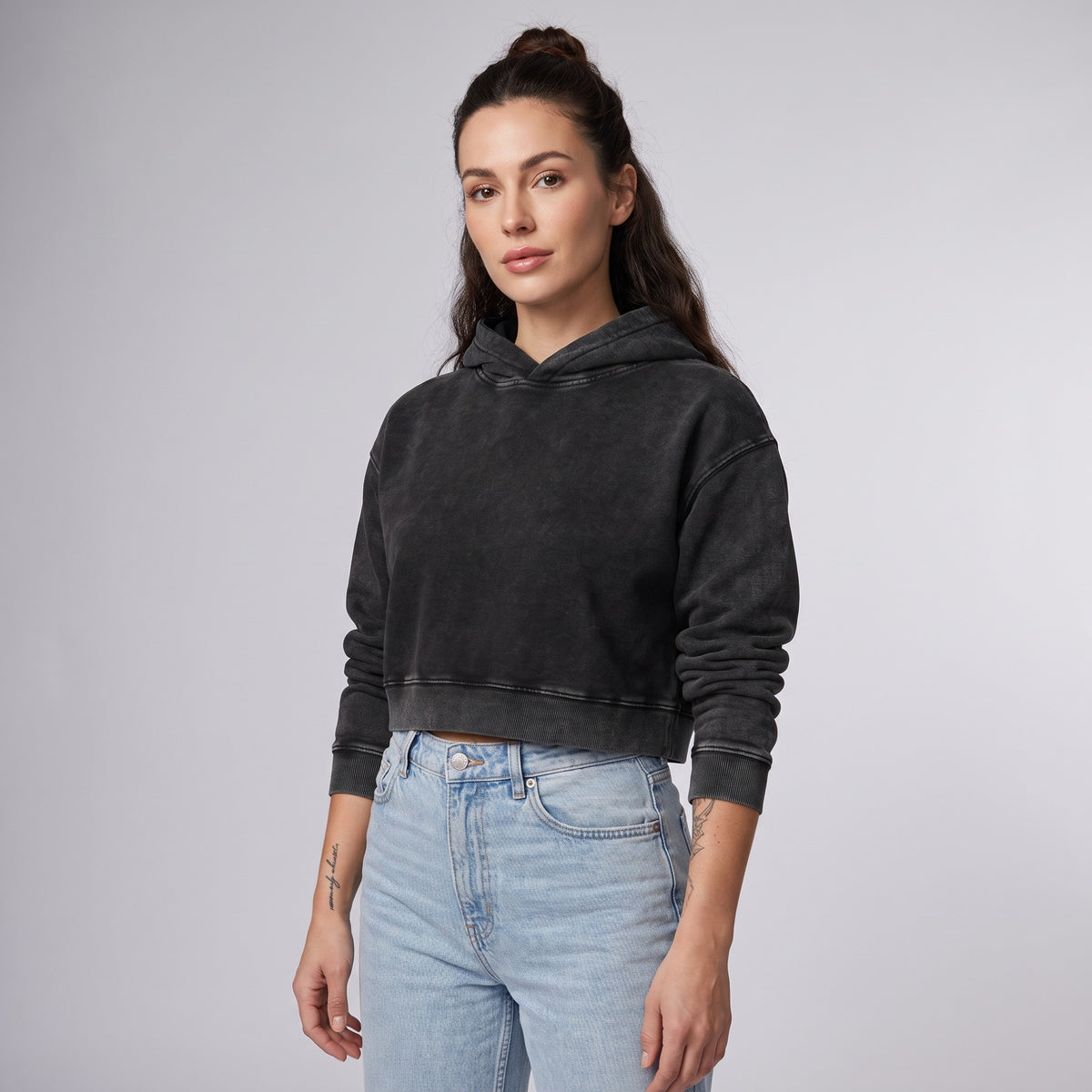 Femme portant le hoodie crop top délavé original noir, photo studio