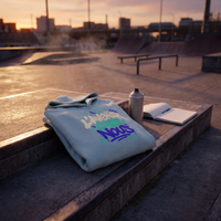 Hoodie oversize Gen Z bleu ciel plié sur les marches d'un skatepark