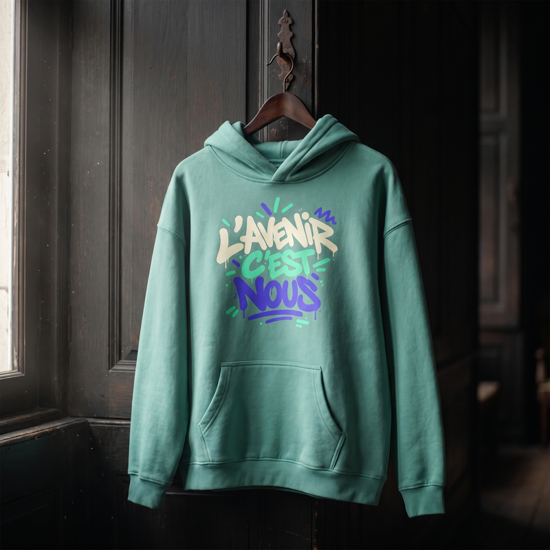 Hoodie oversize Gen Z vert jade L'avenir c'est nous suspendu sur un cintre en bois – hoodie original CHT'M