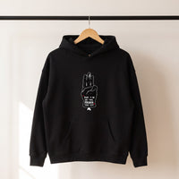 Hoodie oversize original noir Hope suspendu sur un cintre en bois, vue de face