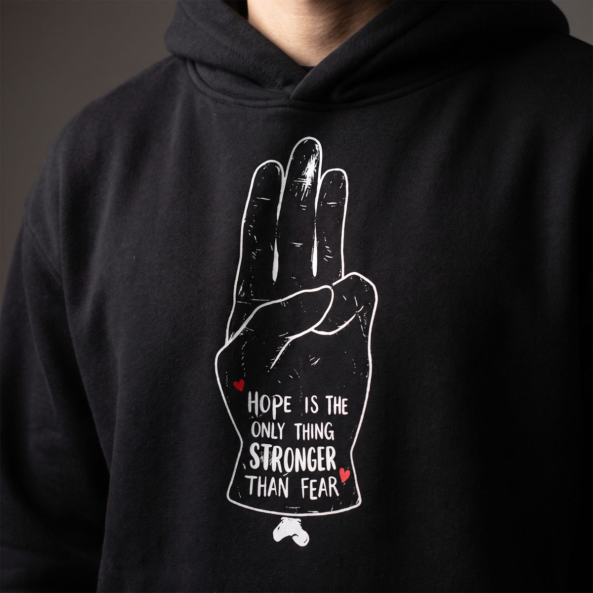 Gros plan du design Hope is the only thing stronger than fear sur le hoodie oversize original noir