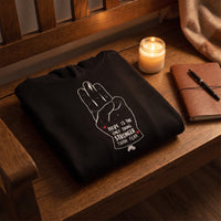 Sweat à capuche noir Hope plié sur un banc en chêne avec une bougie, idée cadeau hoodie original