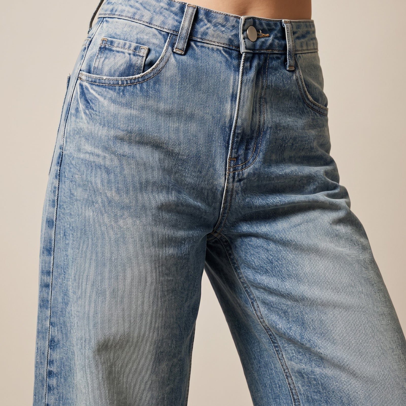 Gros plan du jean large femme original bleu délavé : taille, coupe et texture du denim