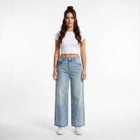 Femme portant le jean large femme original bleu délavé, photo studio fond blanc