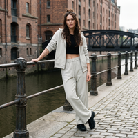 Femme portant le jogging large gris clair à bord brut au bord d'un canal belge