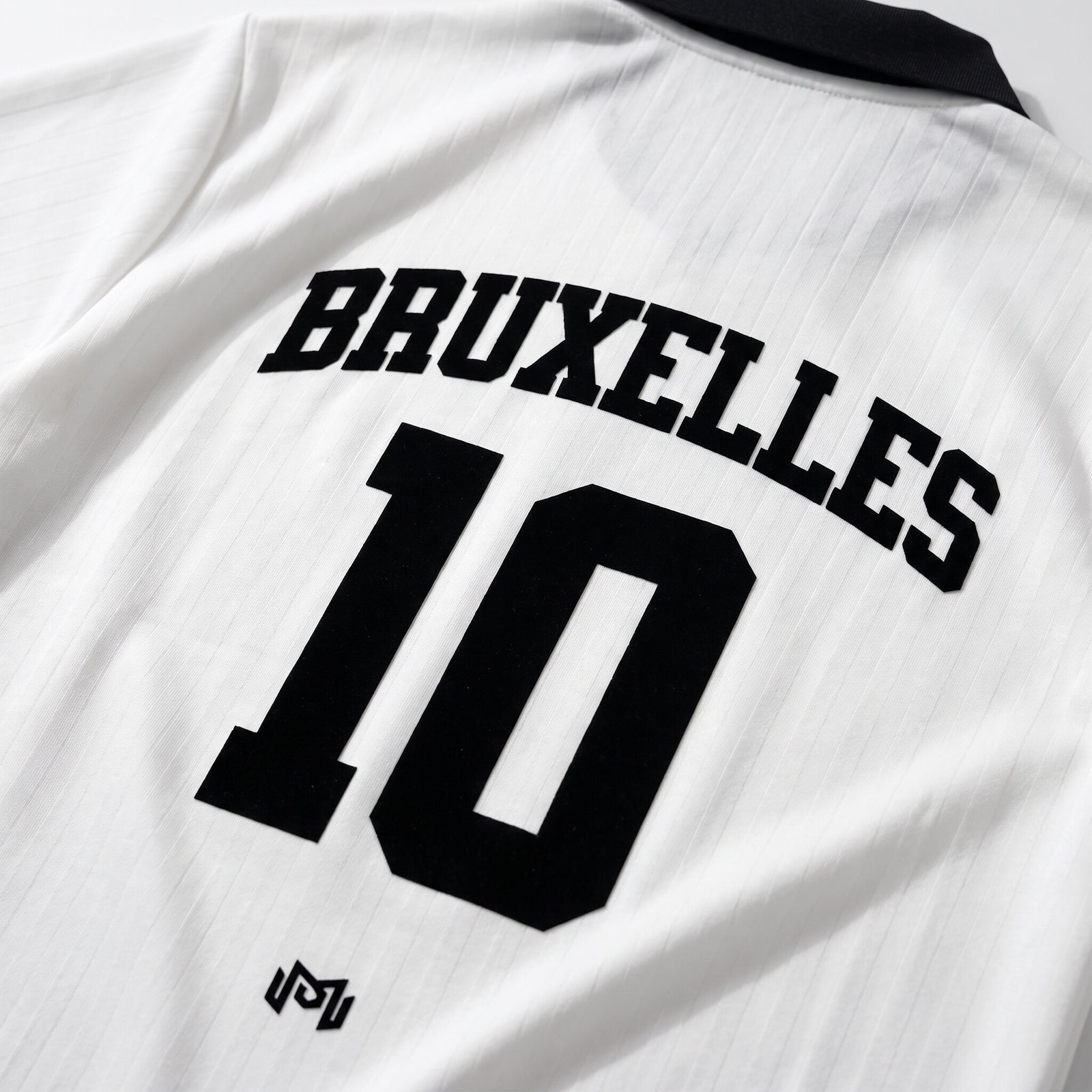 Gros plan du flocage Bruxelles 10 doré au dos du maillot de foot streetwear