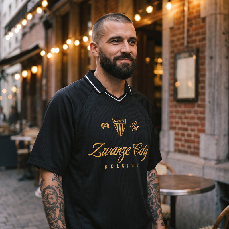 Maillot de foot streetwear belge Zwanze City noir et doré porté en terrasse d'un café bruxellois, style rétro blokecore