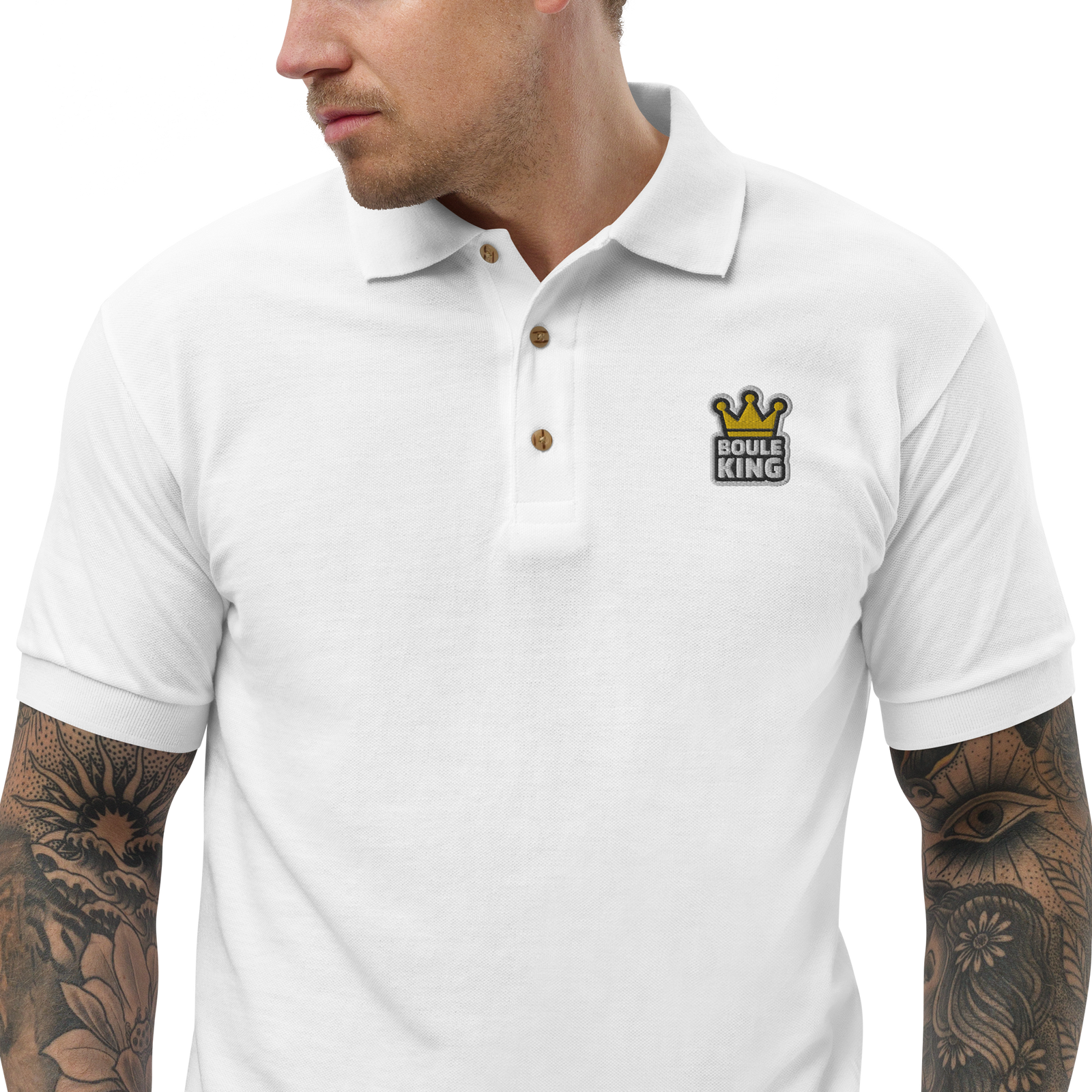 Buste d'un homme tatoué portant le polo de pétanque brodé Boule King blanc