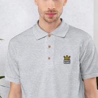Gros plan de la broderie Boule King sur le polo de pétanque gris sport
