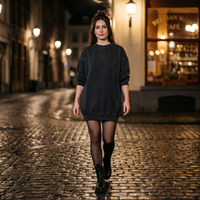 Femme portant la robe sweat oversize noir délavé la nuit sur des pavés