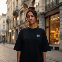 Robe t-shirt oversize noire CHT'M Boutique avec petit logo cœur brodé, portée dans une rue pavée de Bruxelles au coucher du soleil