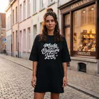 Femme portant la robe t-shirt oversize noire imprimé Made in Belgium with Love dans une rue pavée belge
