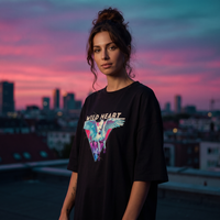 Femme portant la robe t-shirt oversize noire imprimé Wild Heart pégase sur un rooftop au coucher du soleil