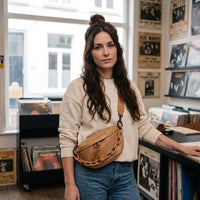 Sac banane femme brun clair en cuir vegan avec chaîne porté par une femme, look streetwear en Belgique | CHT'M Boutique