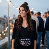 Sac banane fleurs blanches fond noir porté par une femme, look streetwear en Belgique | CHT'M Boutique