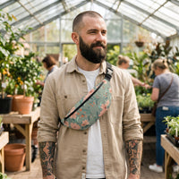 Sac banane fleurs sur fond vert sauge porté par un homme, look streetwear en Belgique | CHT'M Boutique
