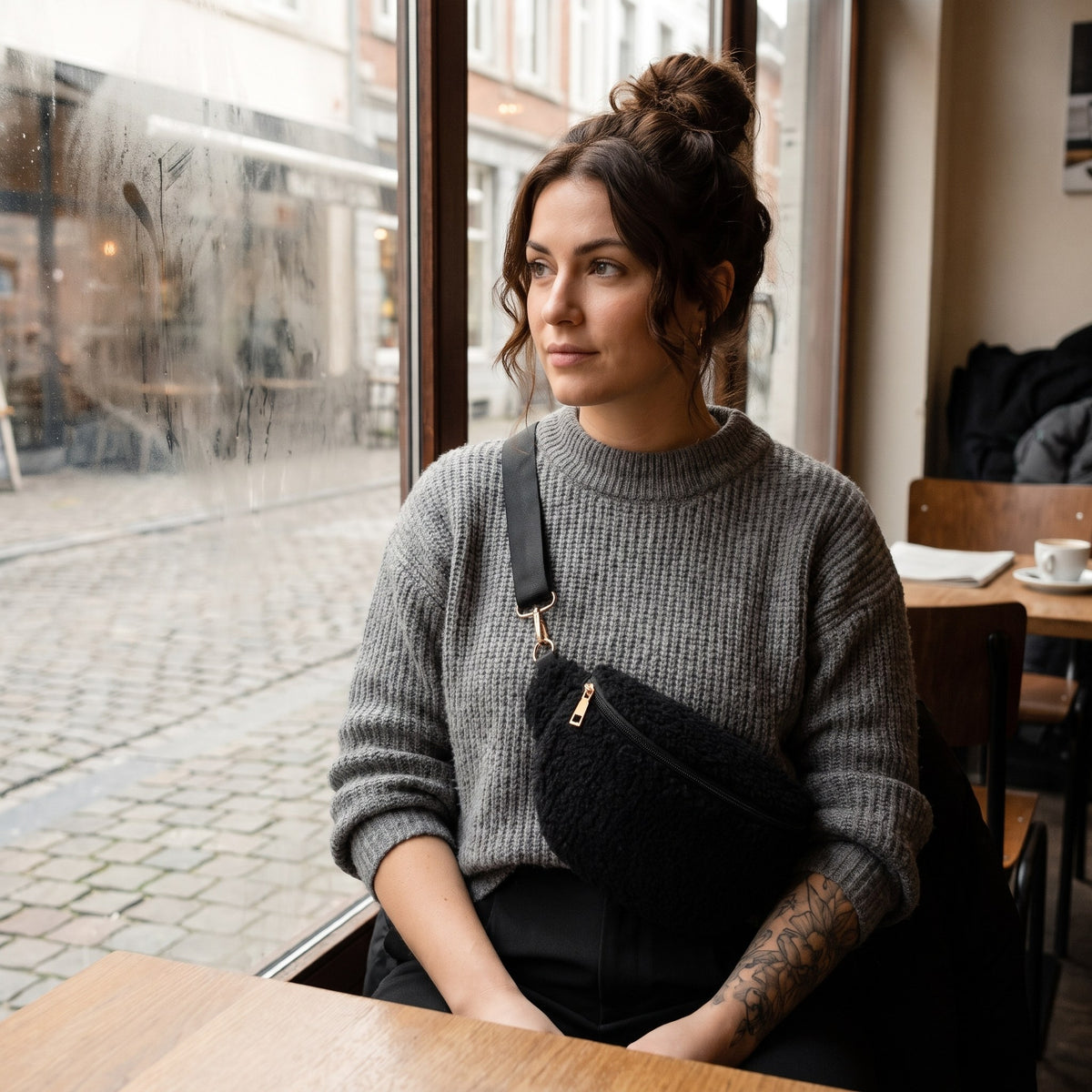 Sac bandoulière moumoute effet teddy noir porté par une femme, look streetwear en Belgique | CHT'M Boutique