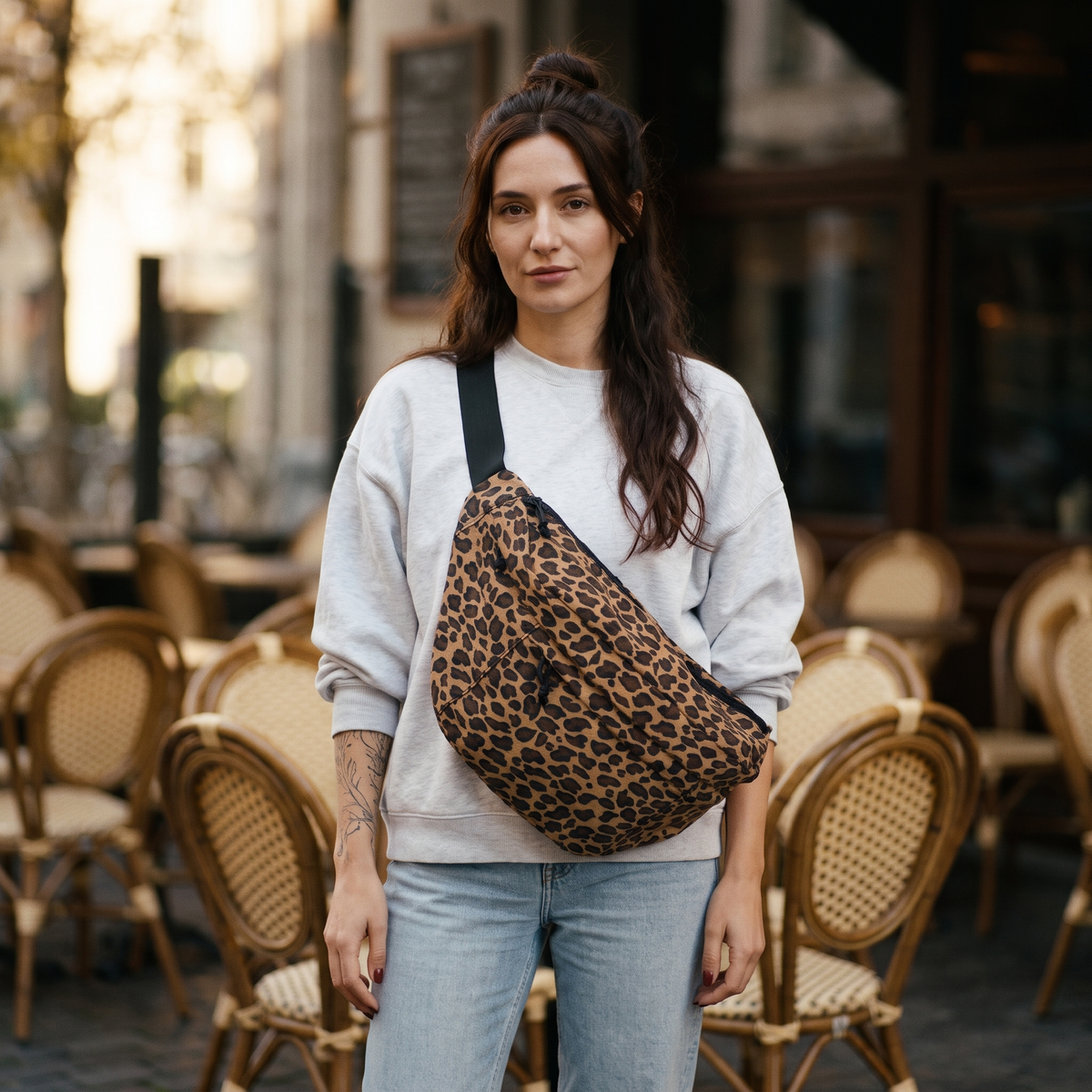 Femme portant le sac banane XXL léopard en bandoulière devant une terrasse de Bruxelles | CHT'M Boutique