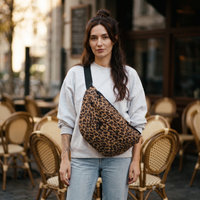 Femme portant le sac banane XXL léopard en bandoulière devant une terrasse de Bruxelles | CHT'M Boutique