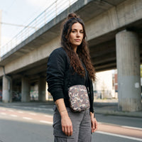 Sacoche bandoulière camouflage gris portée par une femme, look streetwear en Belgique | CHT'M Boutique