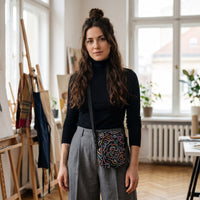 Sac bandoulière noir à gribouillis colorés porté par une femme, look streetwear en Belgique | CHT'M Boutique