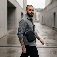 Sacoche bandoulière noire unie portée par un homme, look streetwear en Belgique | CHT'M Boutique