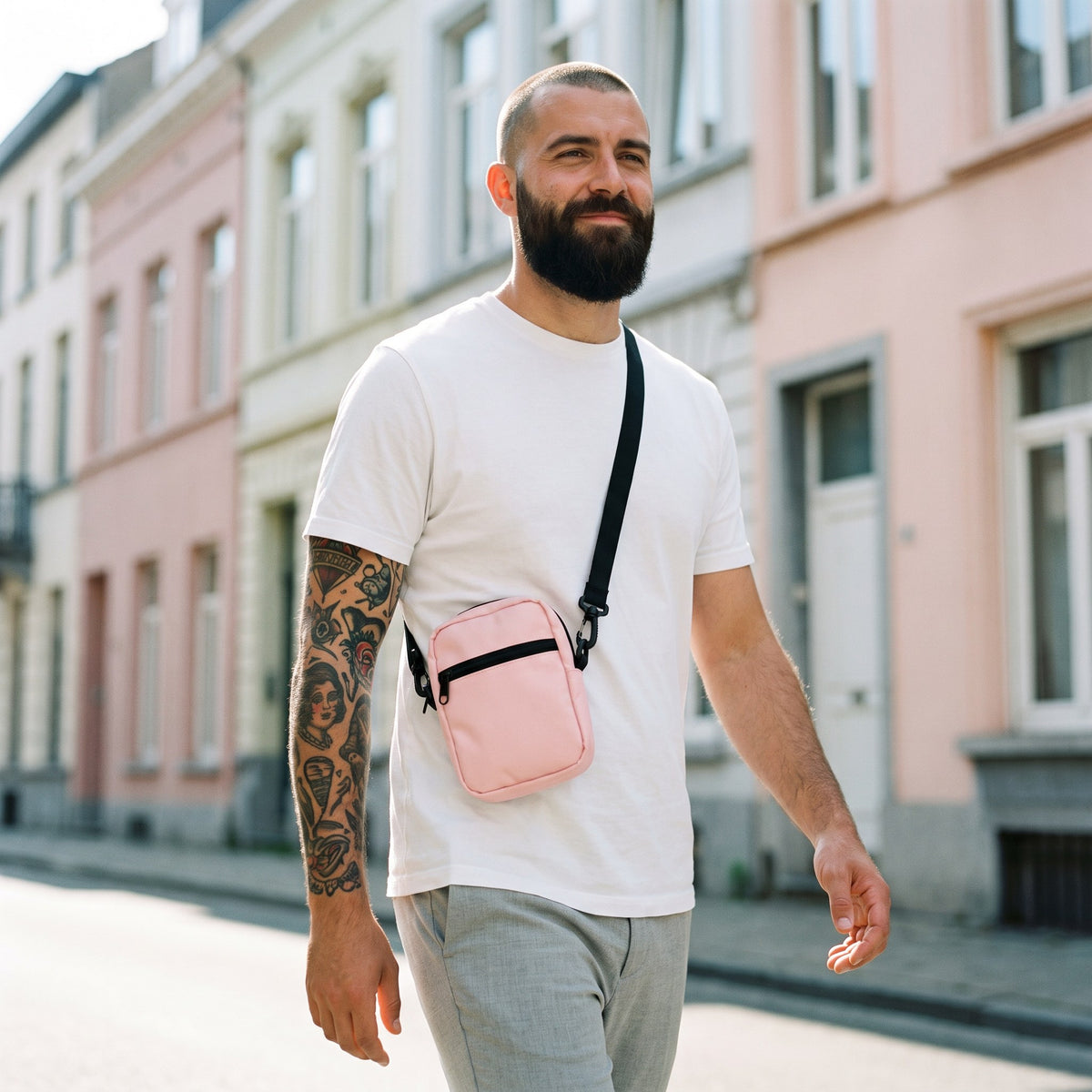Petit sac bandoulière rose pâle porté par un homme, look streetwear en Belgique | CHT'M Boutique