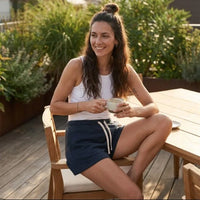 Femme portant le short en molleton original CHT'M en terrasse, coloris bleu marine