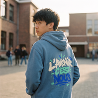 Lycéen de dos portant le sweat à capuche Gen Z « L'avenir c'est nous » bleu acier, grand print dans le dos – sweat manif original