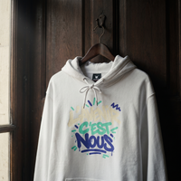 sweat à capuche Gen Z « L'avenir c'est nous » blanc suspendu sur un cintre en bois – sweat Gen Z original CHT'M