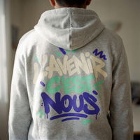 Gros plan du print sur le sweat à capuche Gen Z « L'avenir c'est nous » gris cendré porté