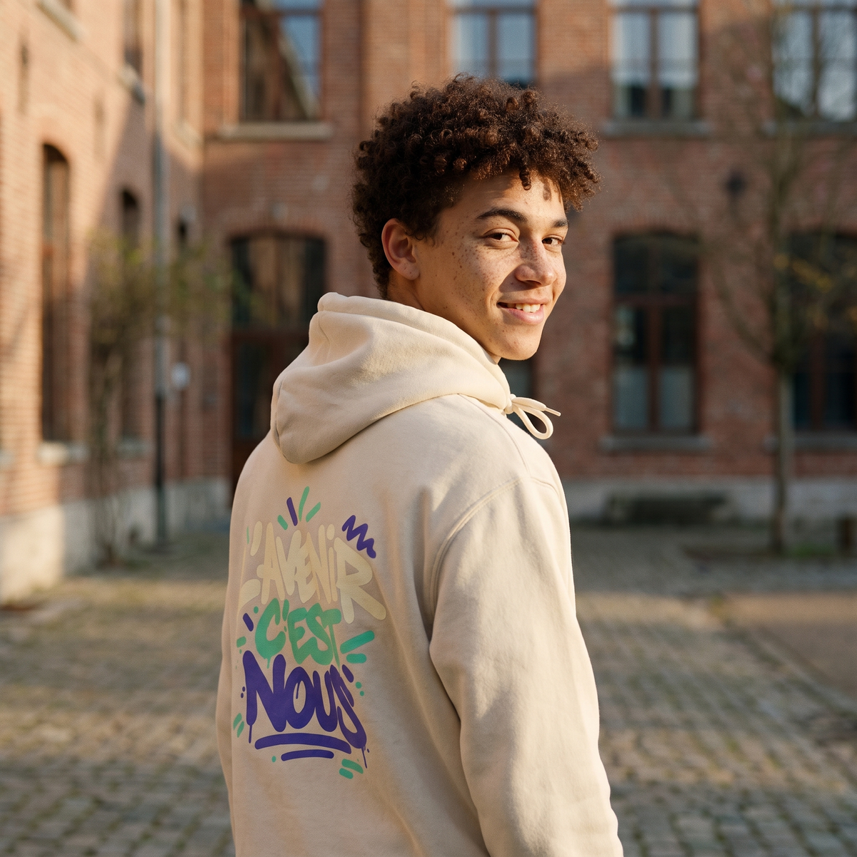 Lycéen de dos portant le sweat à capuche Gen Z « L'avenir c'est nous » crème, grand print dans le dos – sweat manif original