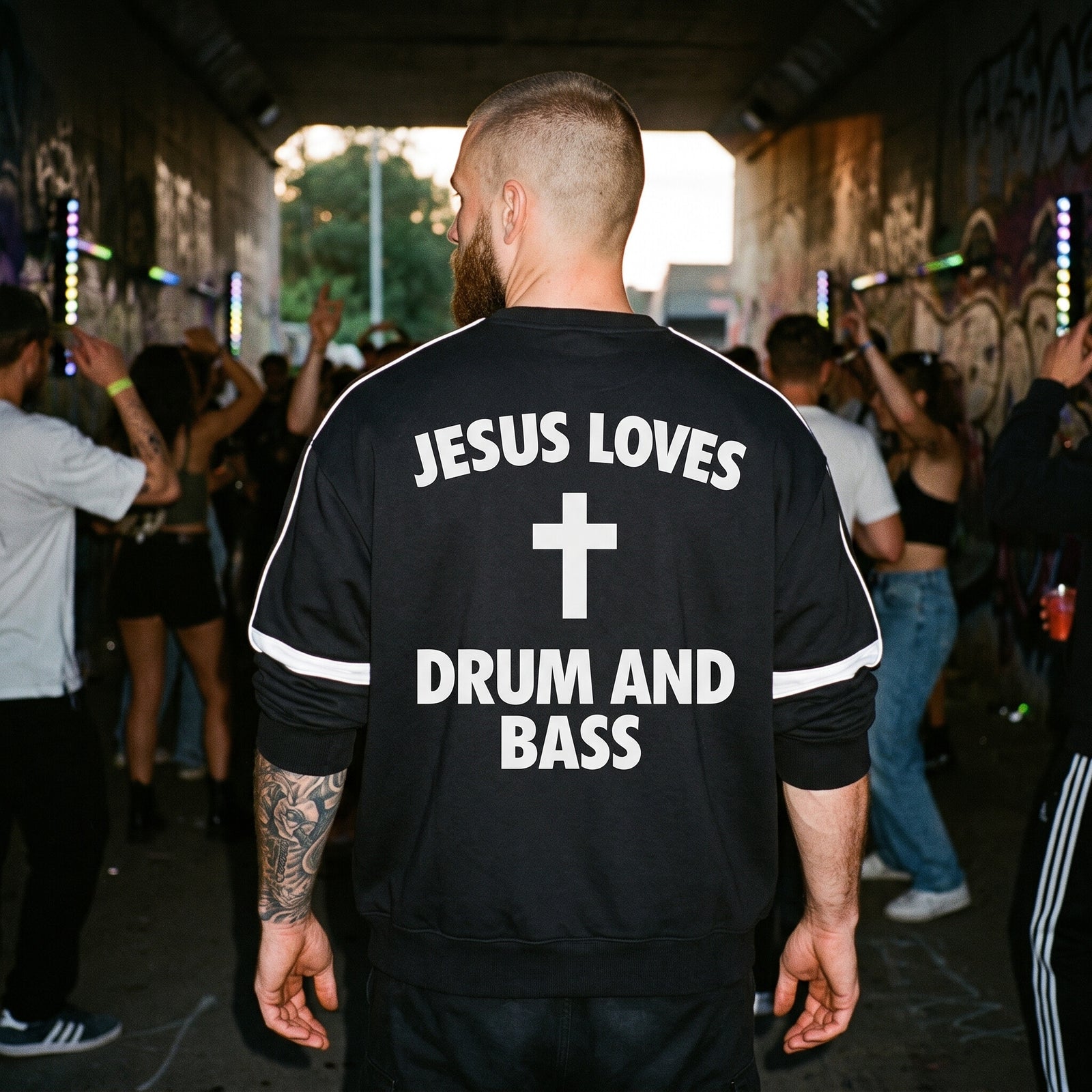 Dos du sweat Drum and Bass noir avec le lettrage Jesus Loves Drum and Bass en soirée rave
