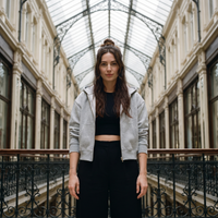 Femme portant le sweat zippé crop top gris chiné ouvert dans une galerie couverte