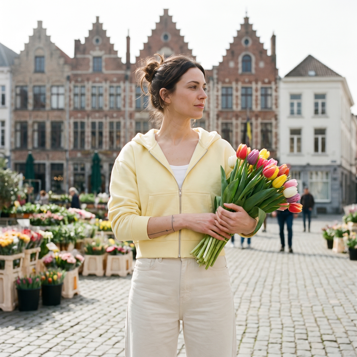 Femme portant le sweat zippé crop top jaune beurre sur un marché aux fleurs belge