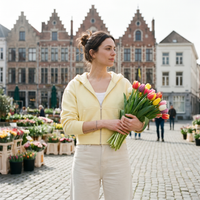 Femme portant le sweat zippé crop top jaune beurre sur un marché aux fleurs belge