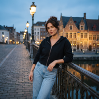 Femme portant le sweat zippé crop top noir avec un jean sur un pont de canal à l'heure bleue